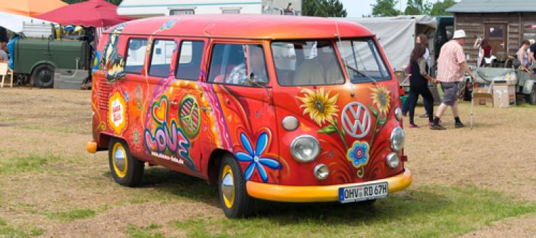 Image of a Volkswagon Van from the sixties with a flower power paint job.