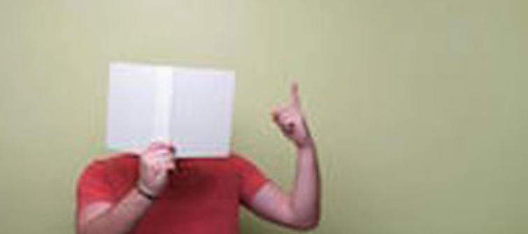 Man with a book in front of his face.