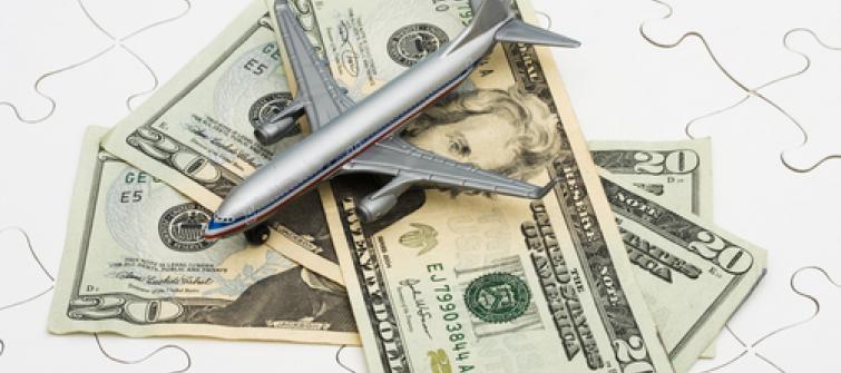 Plane on a pile of money, representing travel expenses