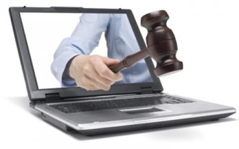 Auctioneer with gavel in laptop.