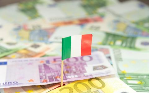 Miniature Italian flag over a pile of Euros.