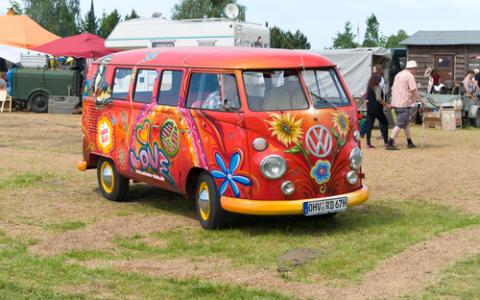 Image of a Volkswagon Van from the sixties with a flower power paint job.