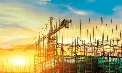Tower crane and building construction site silhouette at sunrise.Industrial background.