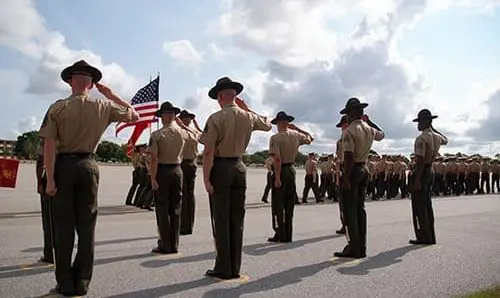 Dramatic shot of Drill Instructors saluting the U.S. flag during the graduation of recruits from US Marine Corps Recruit Depot, Parris Island, SC.