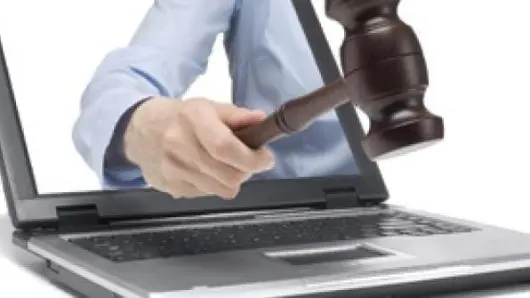 Auctioneer with gavel in laptop.