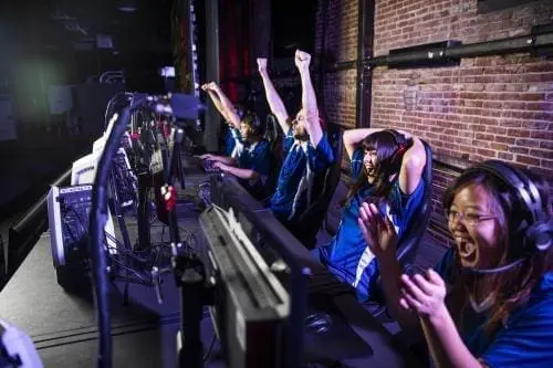 group of gamers celebrating in front of computers