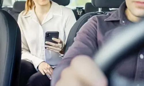 woman on smartphone in backseat of a car