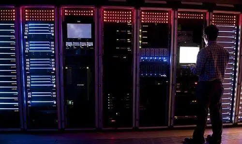 Modern interior of server room in datacenter. IT Engineer in Action Configuring Servers
