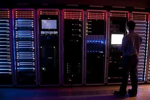 Modern interior of server room in datacenter. IT Engineer in Action Configuring Servers