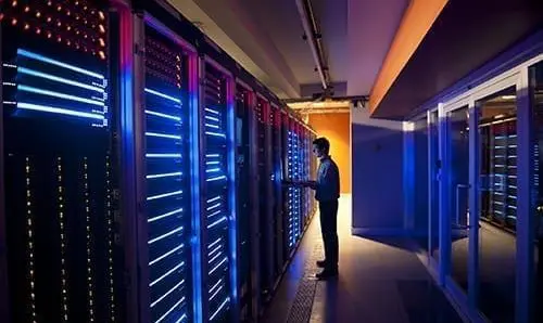 Modern interior of server room in datacenter. IT Engineer in Action Configuring Servers