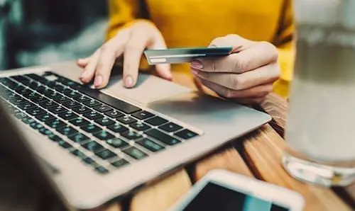 Woman's hands holding credit card and typing on keyboard on laptop