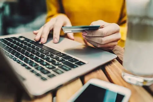 Woman's hands holding credit card and typing on keyboard on laptop