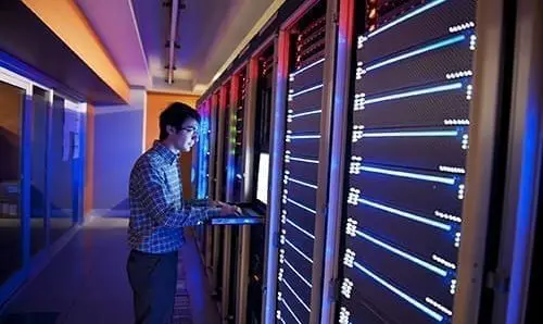 Modern interior of server room in datacenter. IT Engineer in Action Configuring Servers