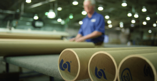 close up of pipes in a warehouse with sonoco logo