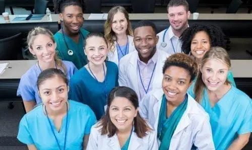 group of medical professionals smiling up at a camera