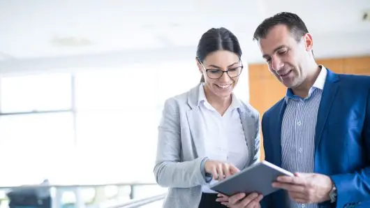 Two people working together with a tablet in an office