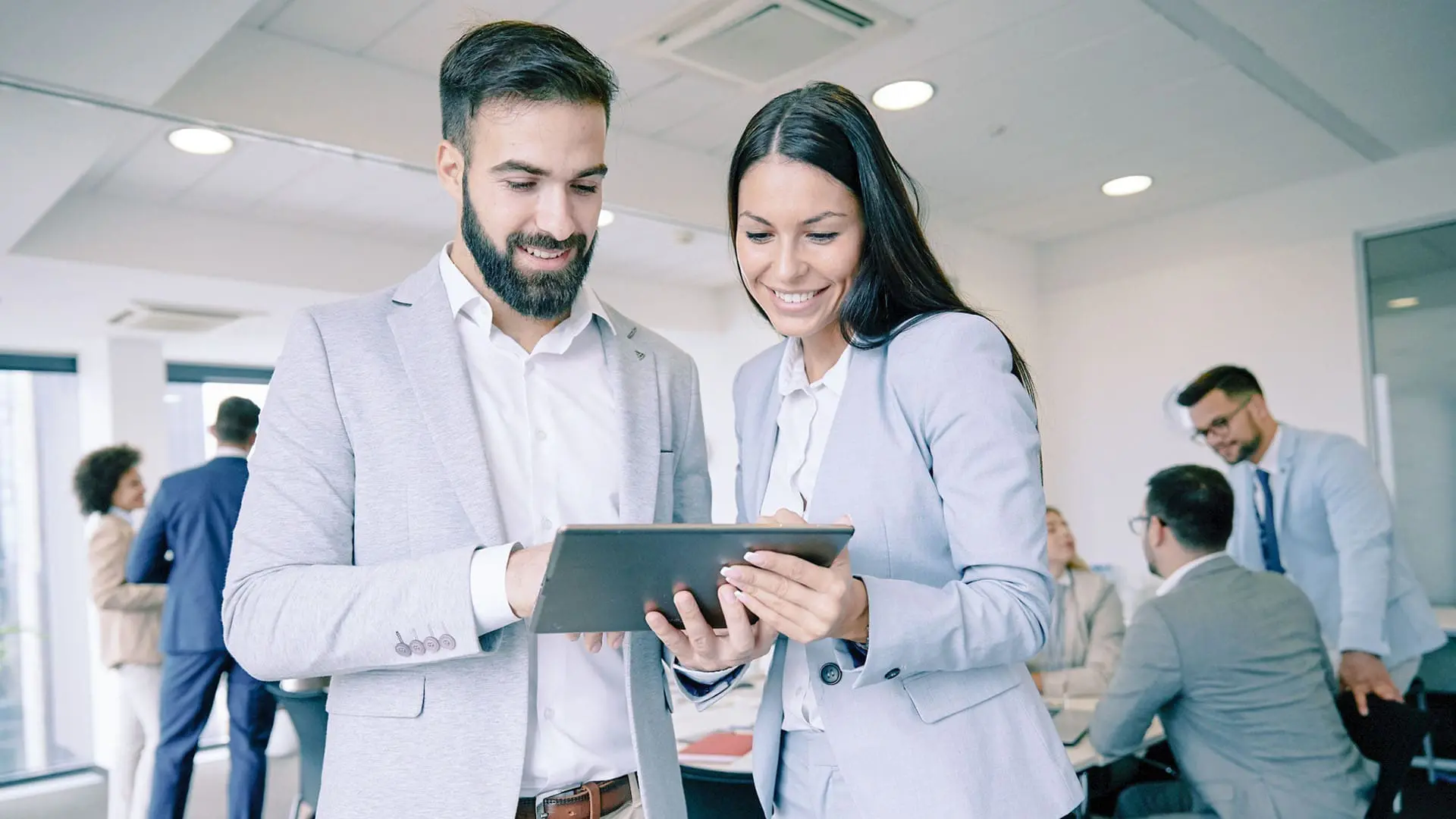coworkers-looking-at-tablet-1224995799