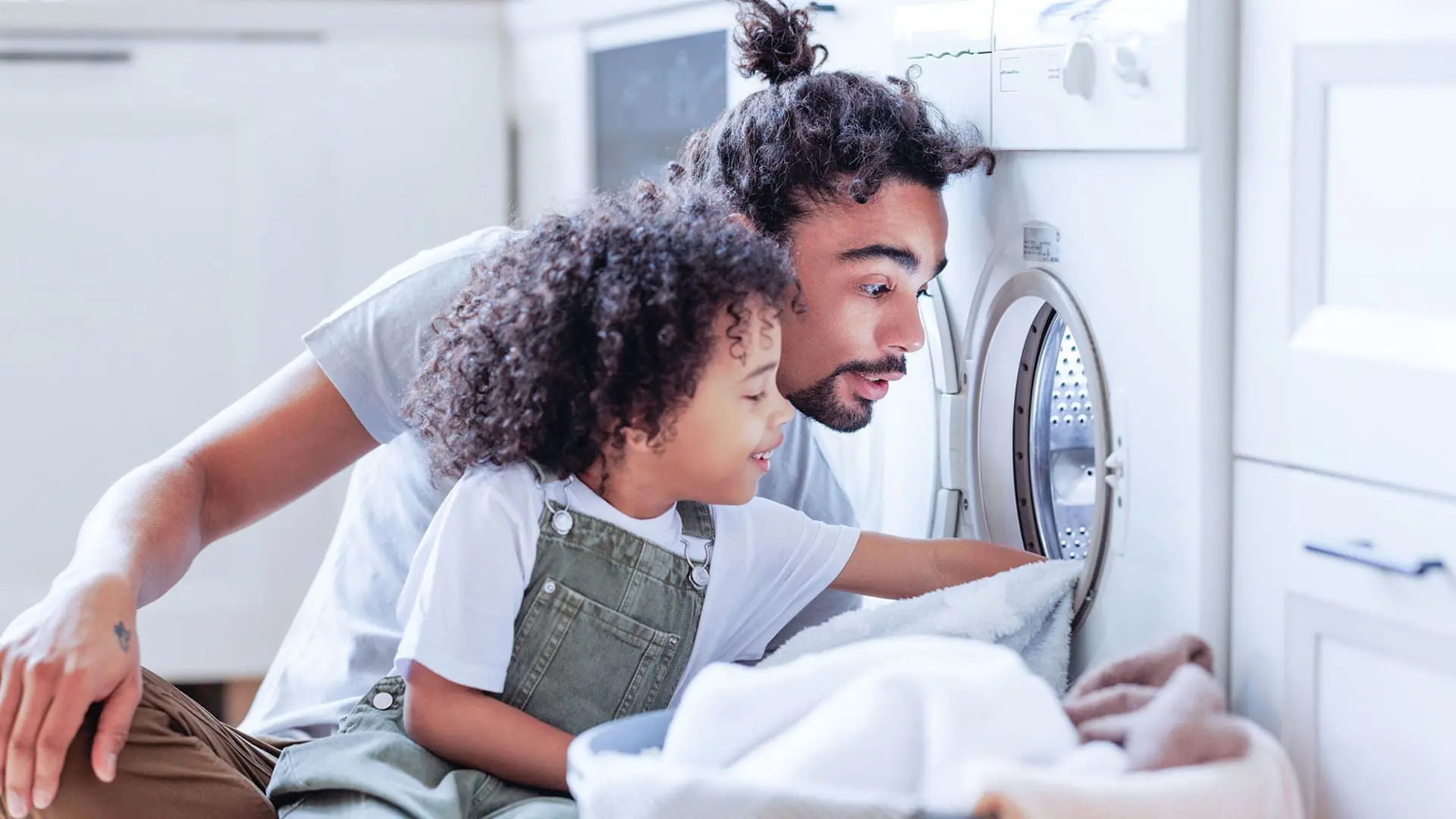 father and daughter doing laundry