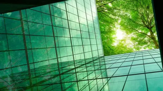 Abstract image of a building with glass windows and green trees