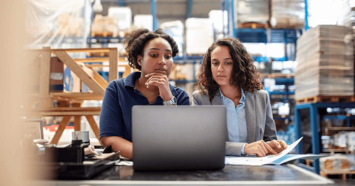People working on a laptop in a warehouse