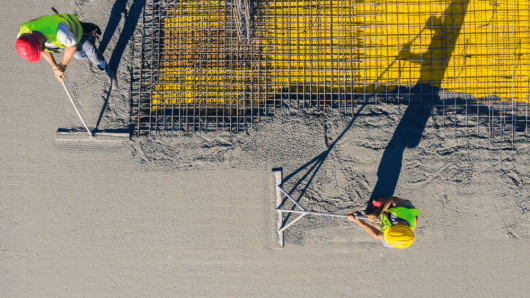 People smoothing concrete.