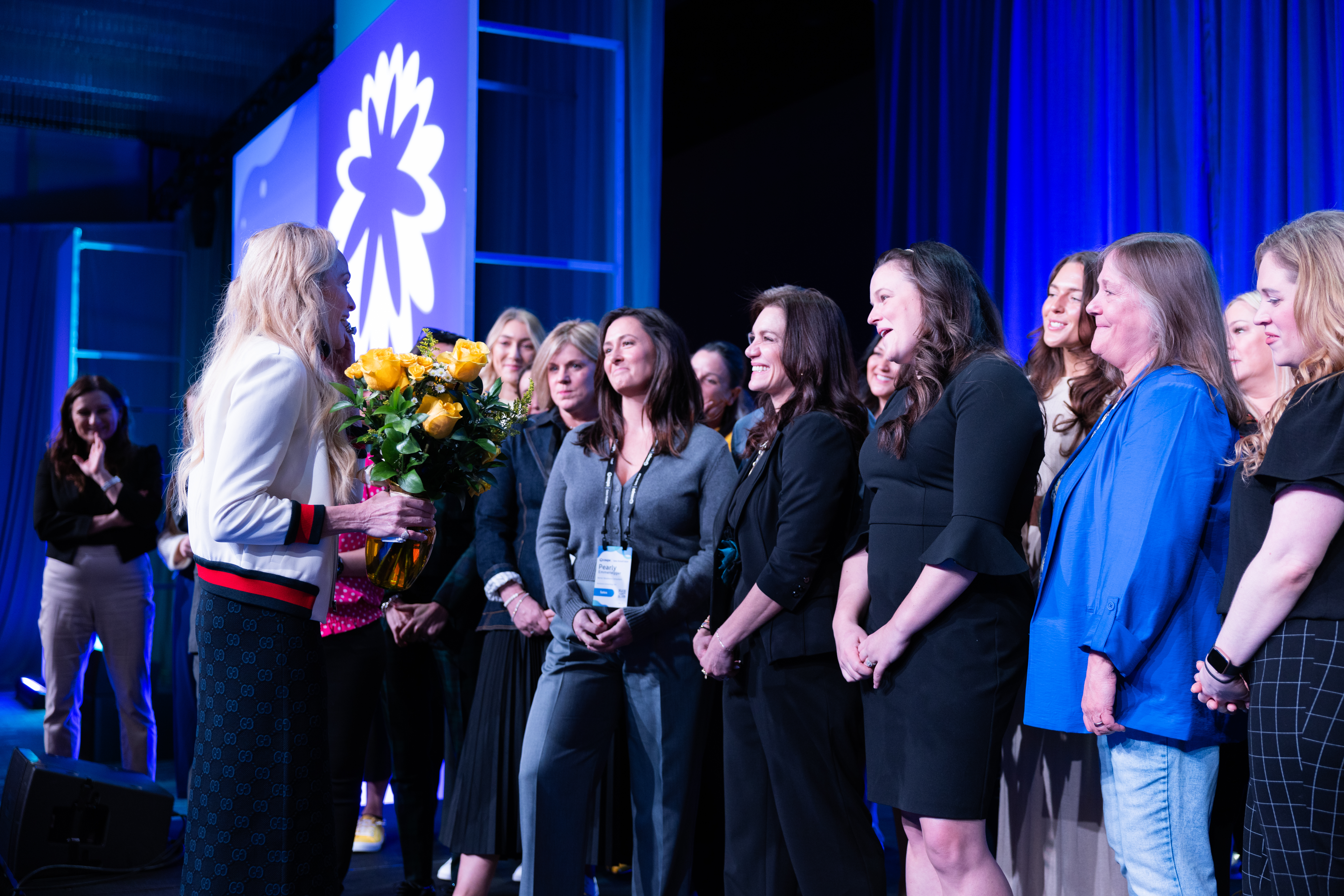 Coupa CEO Leagh Turner being presented with yellow flowers