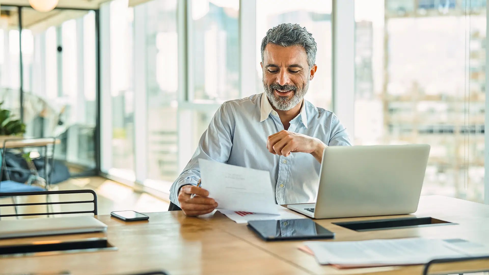 Man reviewing paperwork at a desk.