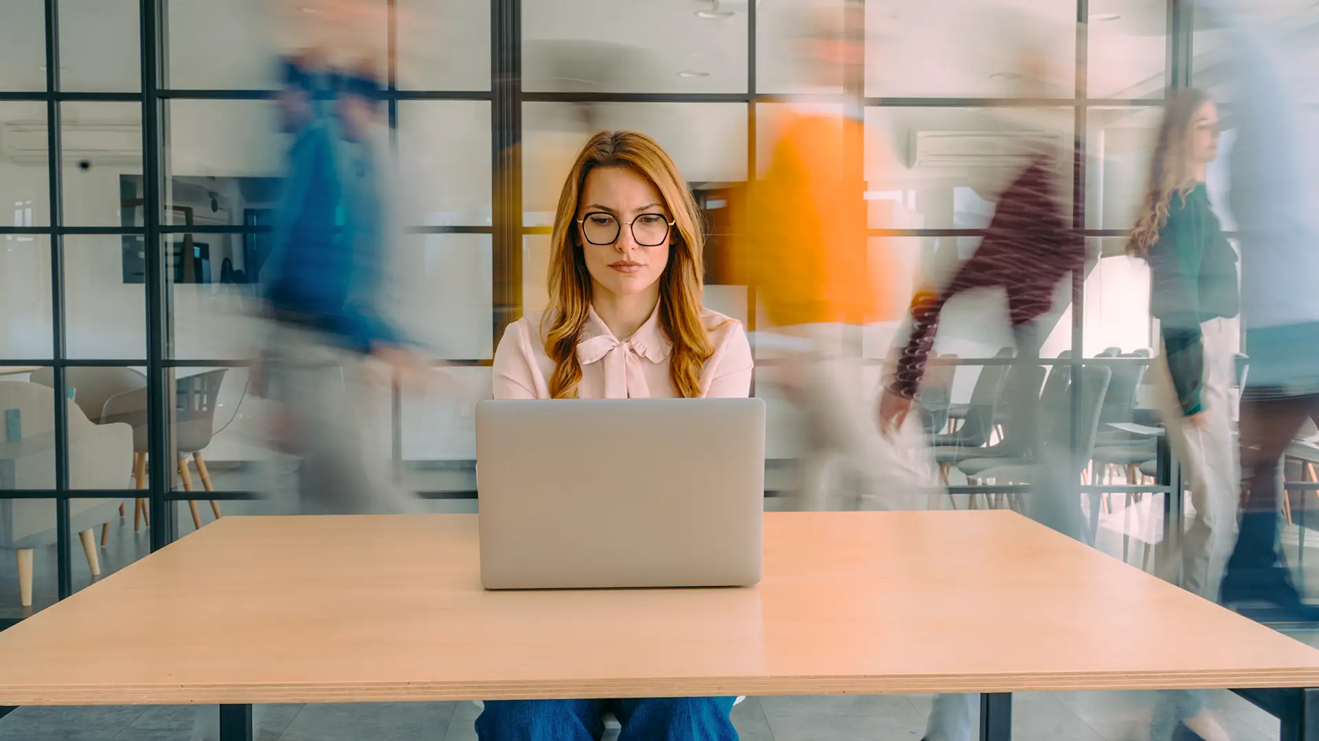 Woman sitting at a desk working on a laptop.